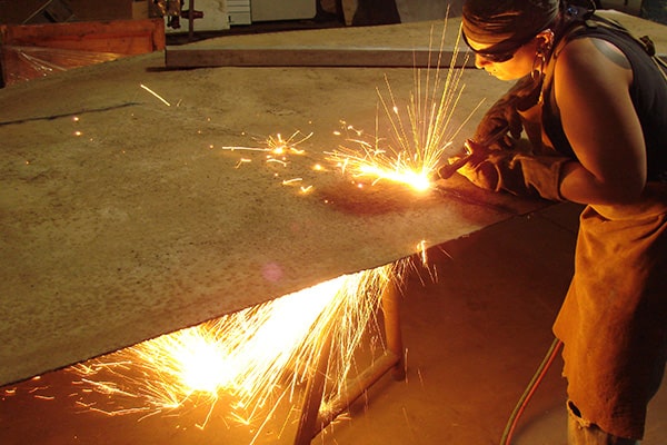 Welder welding pieces of metal in City Museum